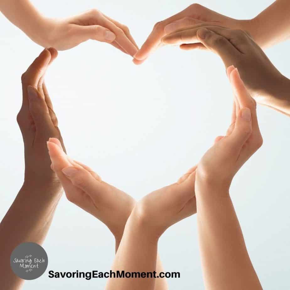 Women's hands making a heart shape as they learn Bible verses about loving others