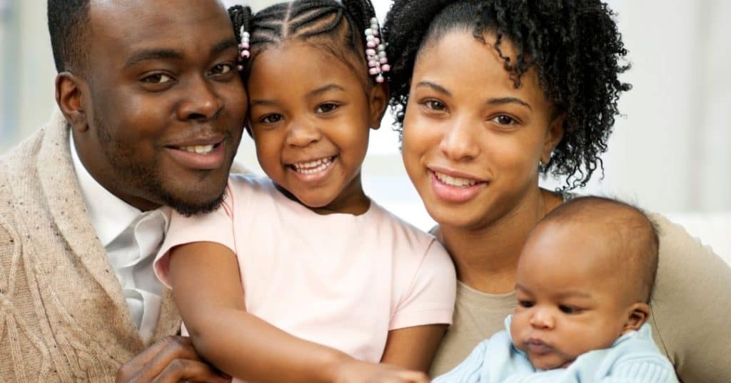 family sitting on couch together teaching their children the importance of moral values