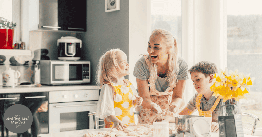 Mom wearing an apron with her children in the kitchen working on how to be a good mom.