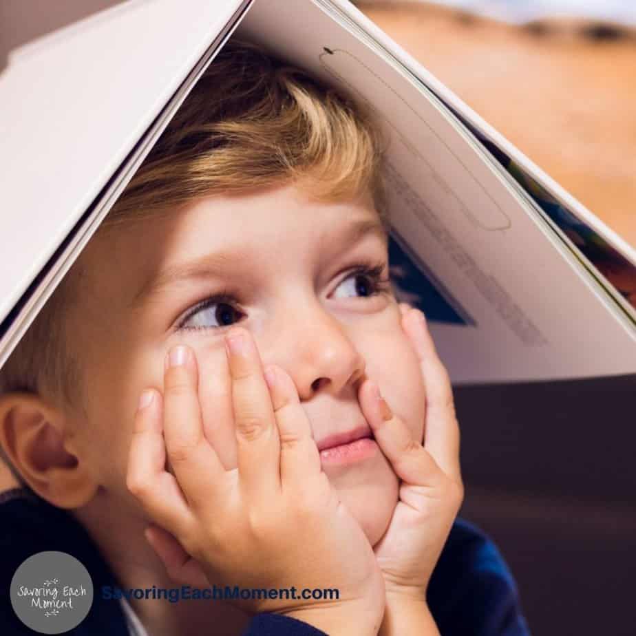Little boy with a book on his head - Learning through Play
