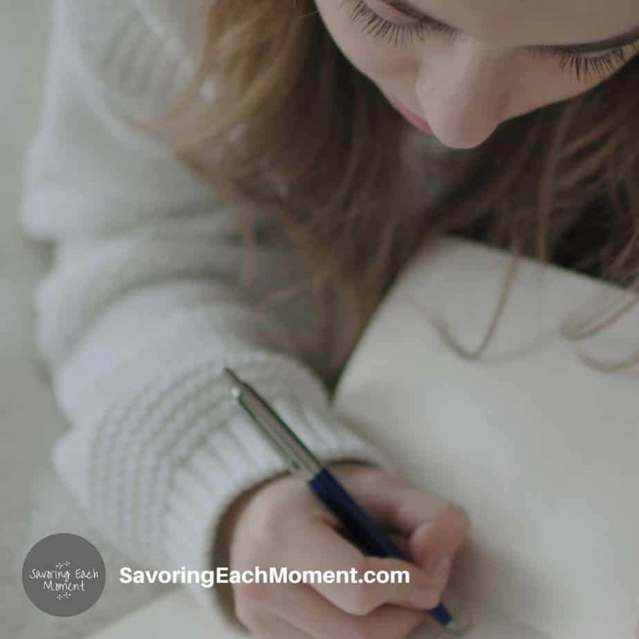 girl writing in her prayer journal for kids