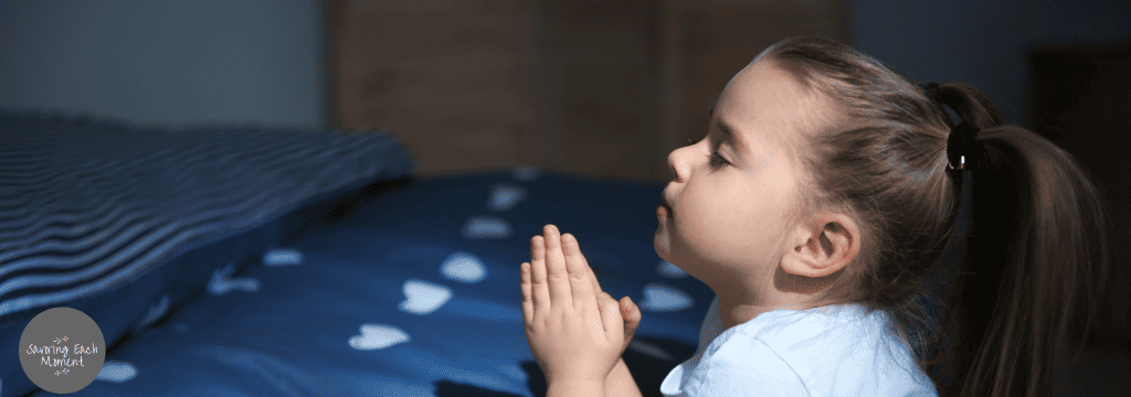 little girl praying to not have bad dreams beside her bed.  