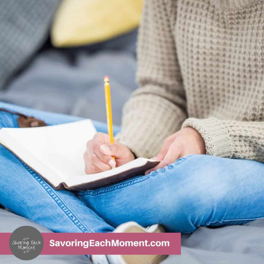 lady with journal in her lap writing with a pencil