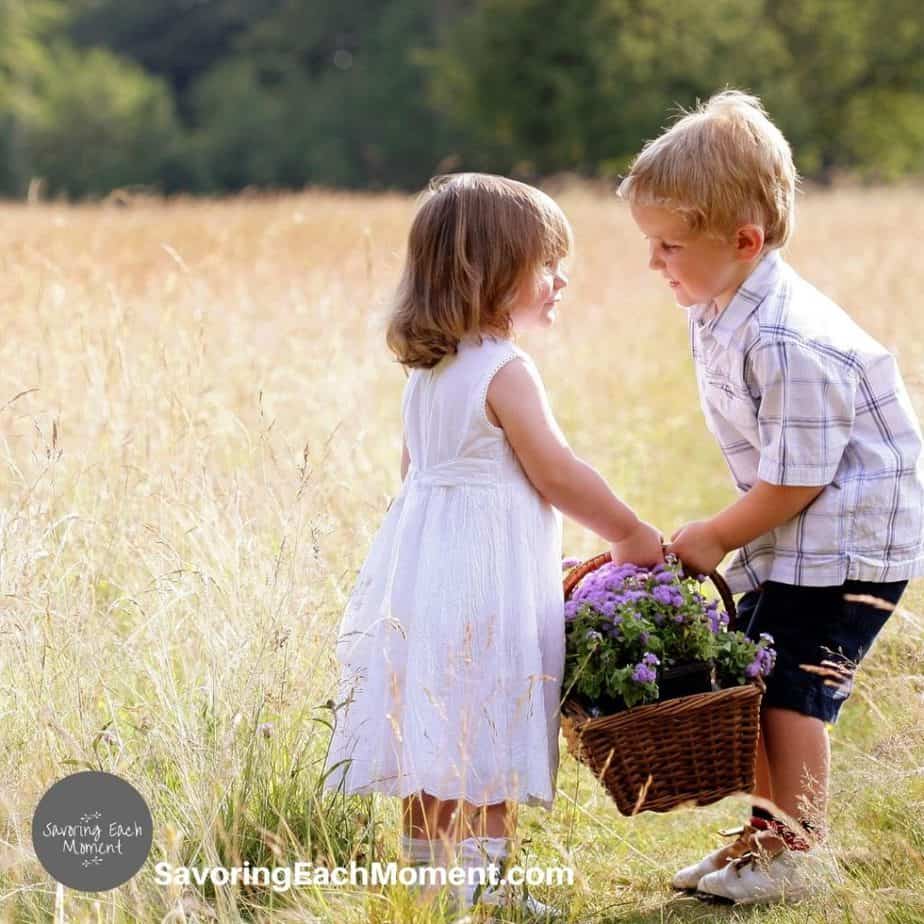 little boy giving a basket of flowers to a little girl being kind