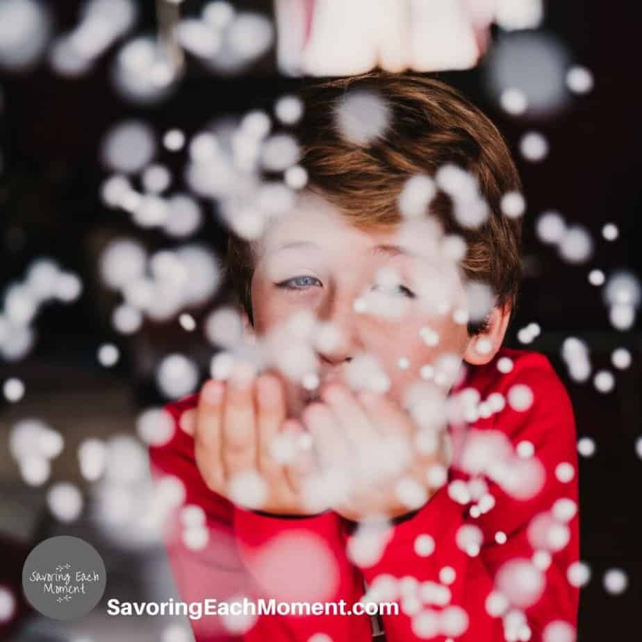 child blowing snow after reading books about winter